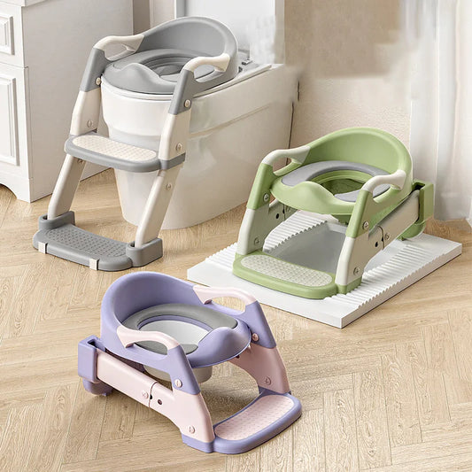 Three children's step toilet stools in different colors on a wooden floor.