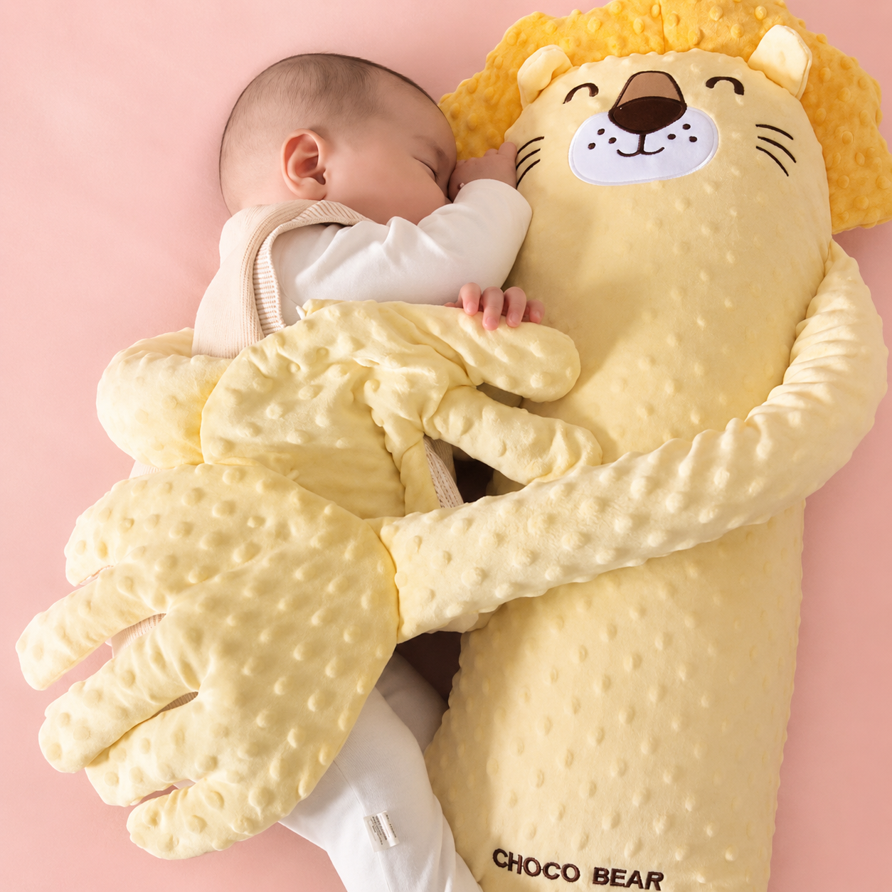 Baby hugging a lion-shaped plush toy with 'Choco Bear' branding