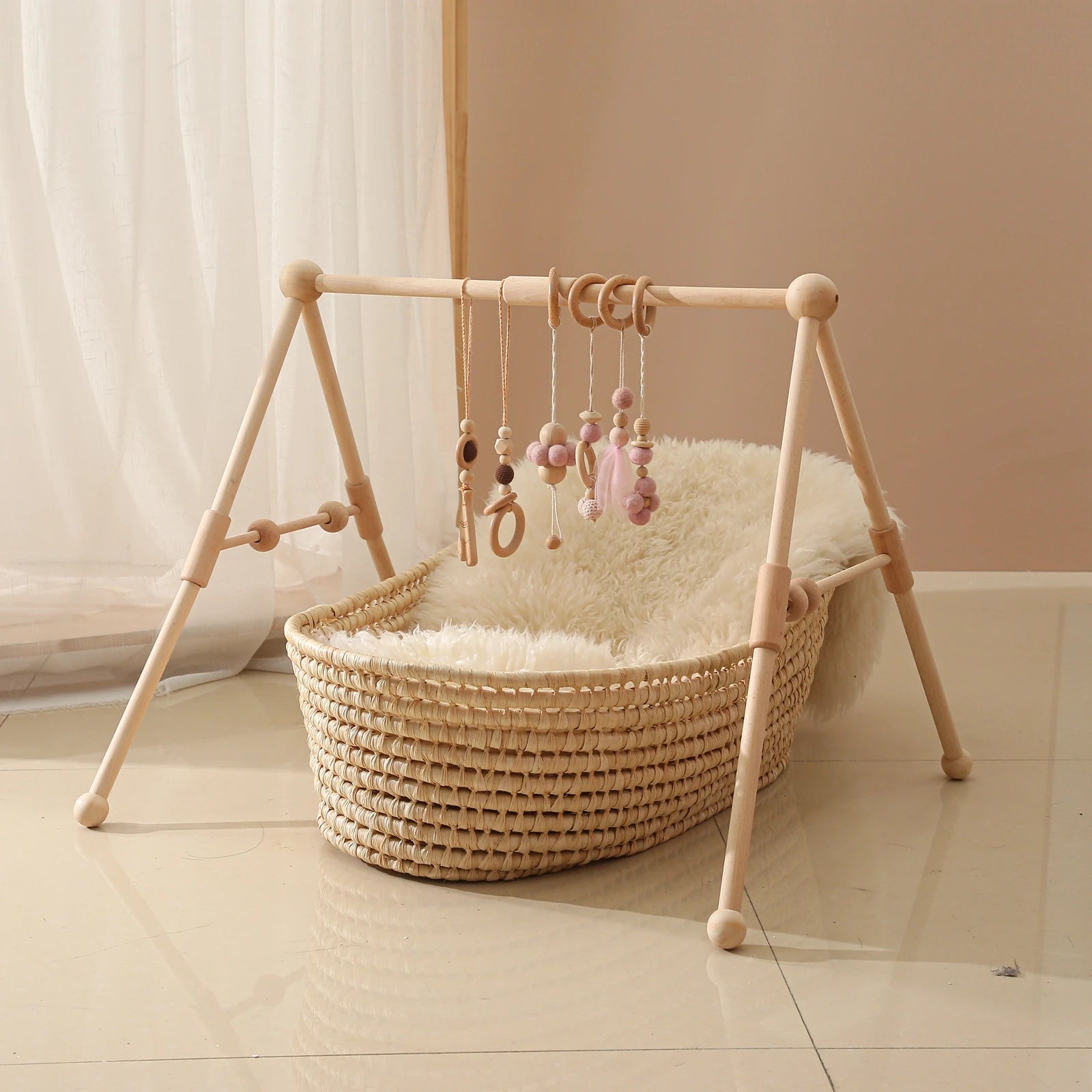 Baby crib with wooden frame and rattan basket on a light wooden floor.