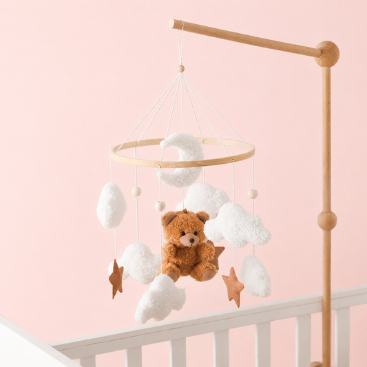 Baby crib mobile with teddy bear and clouds on a pink background