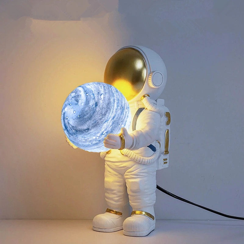 Astronaut lamp holding a glowing blue planet against a white background