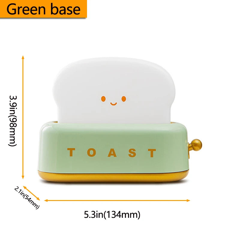 Small toaster night light bed lamp with a green base and white top, featuring dimensions on a white background.
