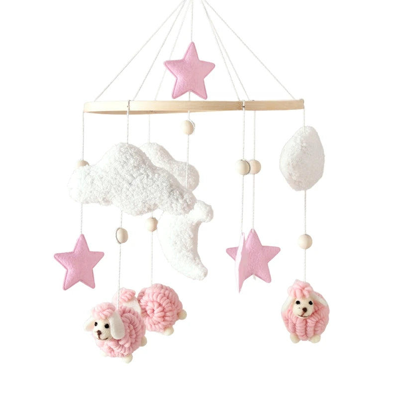Pink baby mobile with sheep, stars, and clouds on a white background