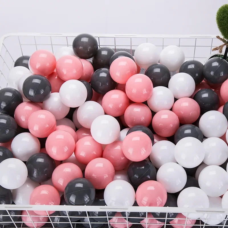 Basket filled with pink, black, and white balls for tent ball pitt