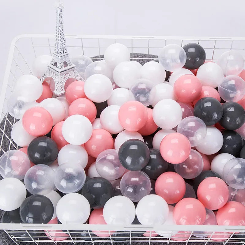 Basket filled with pink, gray, and white balloons for tent ball pitt