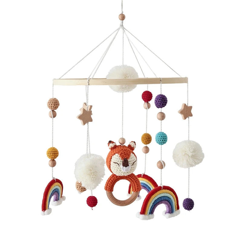 Colorful baby crib mobile with fox, rainbows, and stars on a white background