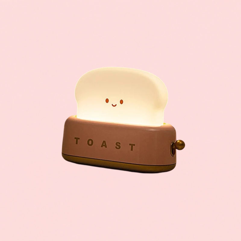 Toy toaster with a smiling face on a pink background
