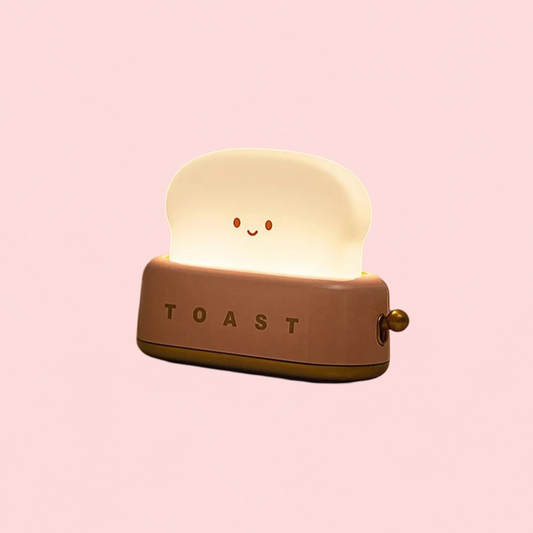 Toy toaster with a smiling face on a pink background