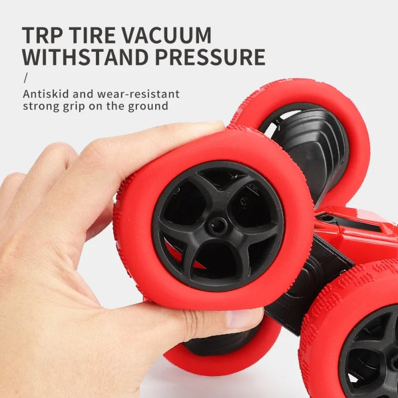 Red tire vacuum with black wheels held by a hand against a light gray background