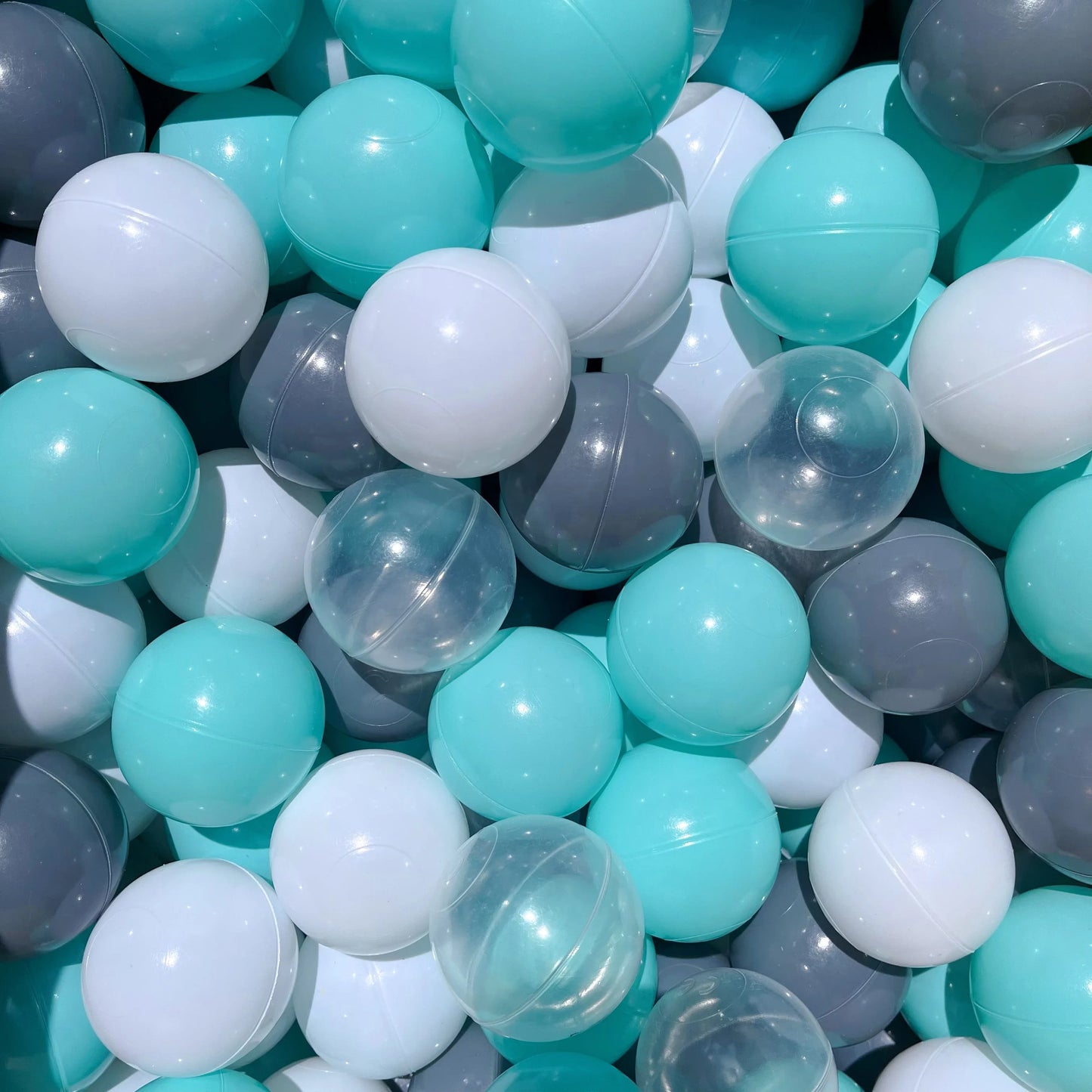Close-up of a pile of teal, gray, and white balls for tent ball pitt
