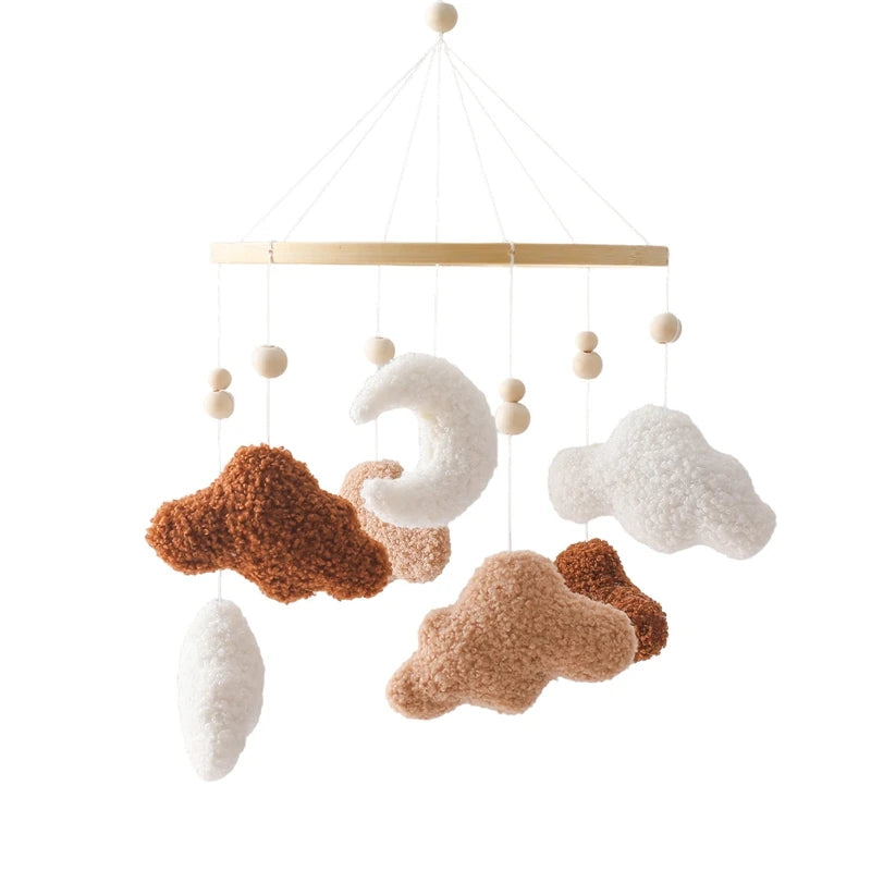 Decorative crib mobile with cloud and moon shapes on a white background