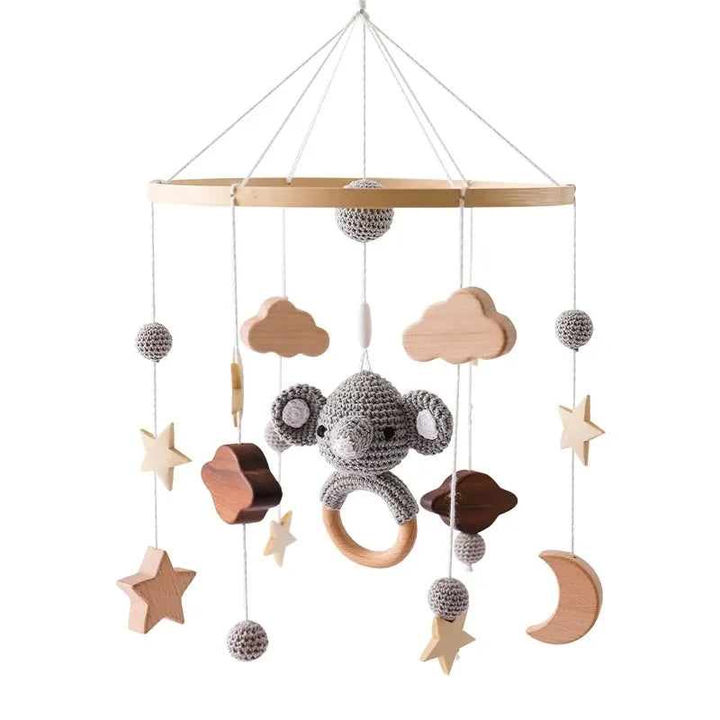 Baby  crib wooden and felt mobile with hanging toys including a monkey, stars, clouds, and moons.