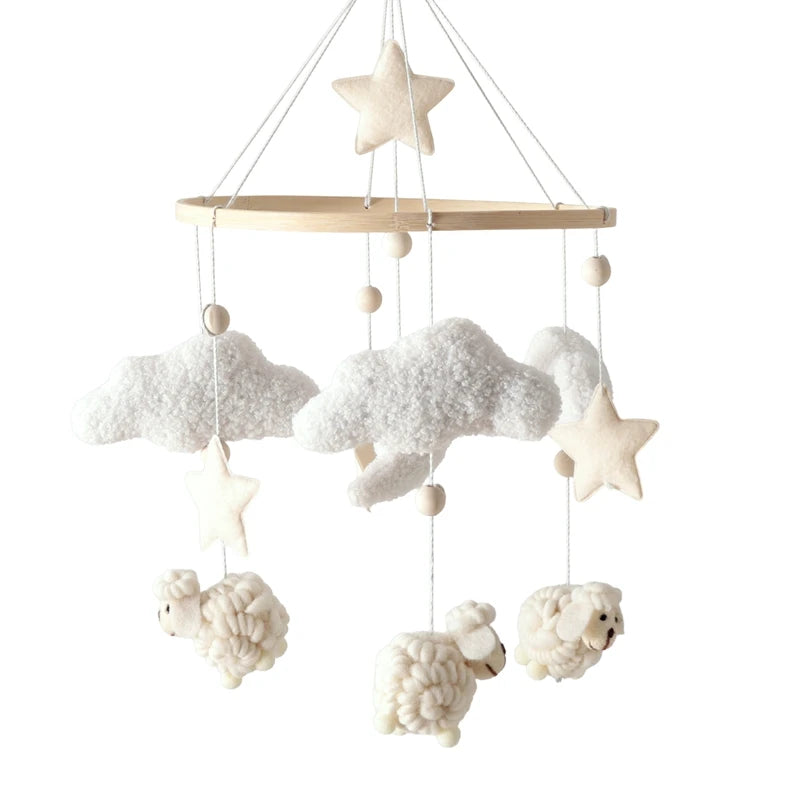 Decorative baby crib mobile with clouds, stars, and sheep hanging from a wooden rod on a white background.